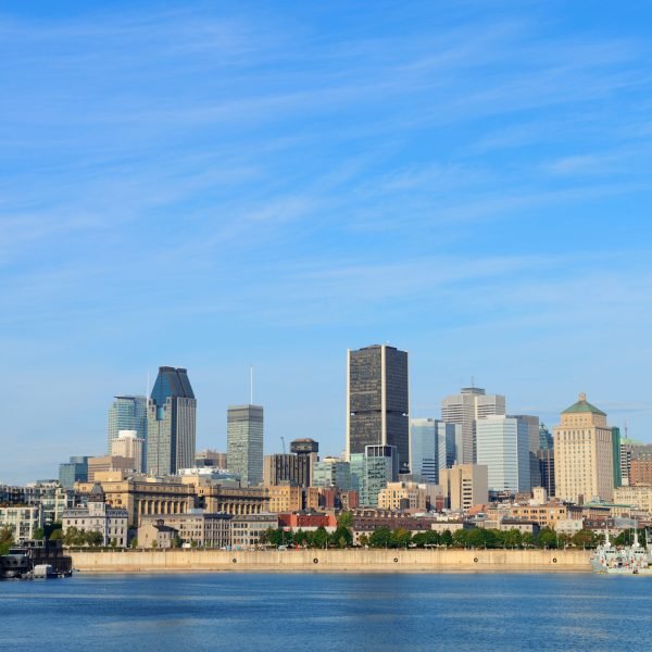 Montreal city skyline over river in the day with urban buildings